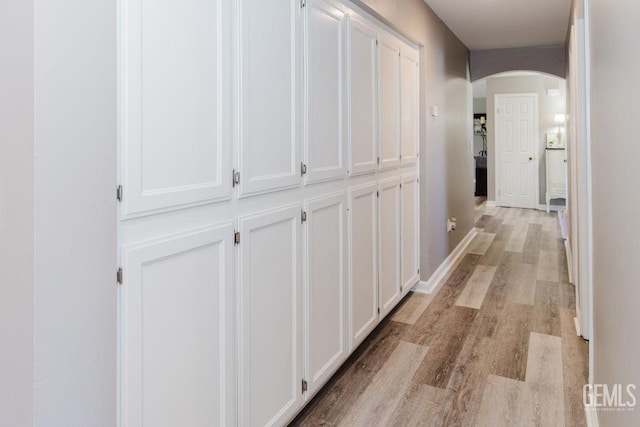 7116 Jolynn St, Bakersfield, CA 93308 - hallway with arched walkways, light wood-style floors, and baseboards