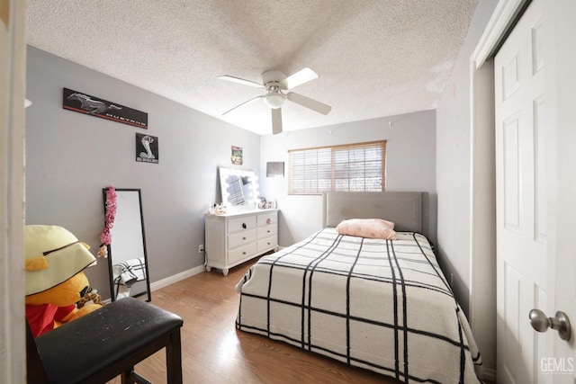 bedroom featuring ceiling fan, a closet, a textured ceiling, and wood-type flooring