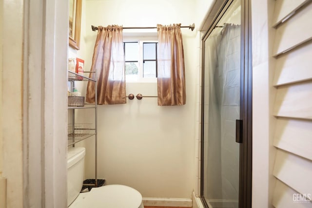 bathroom with toilet and a shower with shower door