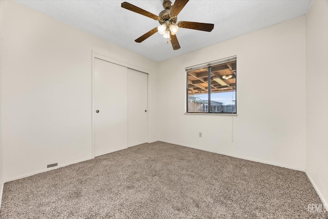 unfurnished bedroom featuring a ceiling fan, carpet, a closet, and a textured ceiling