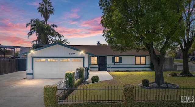 view of front of house with a front yard, concrete driveway, a garage, and fence