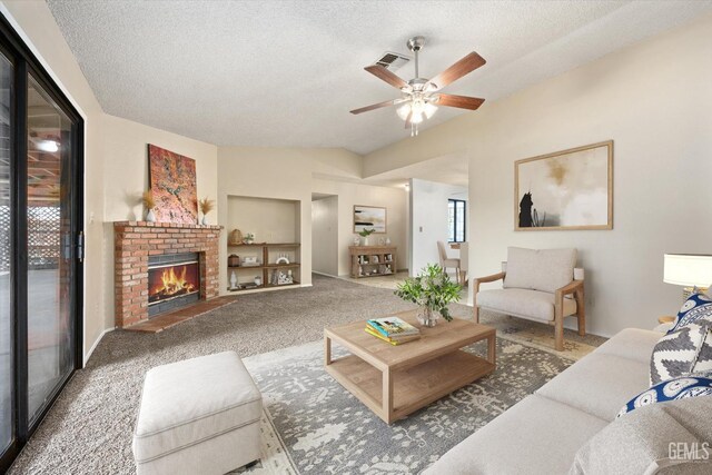 carpeted living area with visible vents, built in features, a textured ceiling, a fireplace, and lofted ceiling