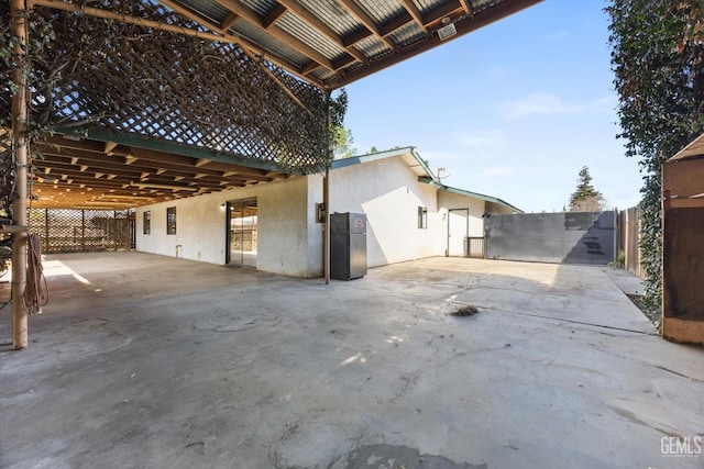 view of patio / terrace with an attached carport, driveway, and fence