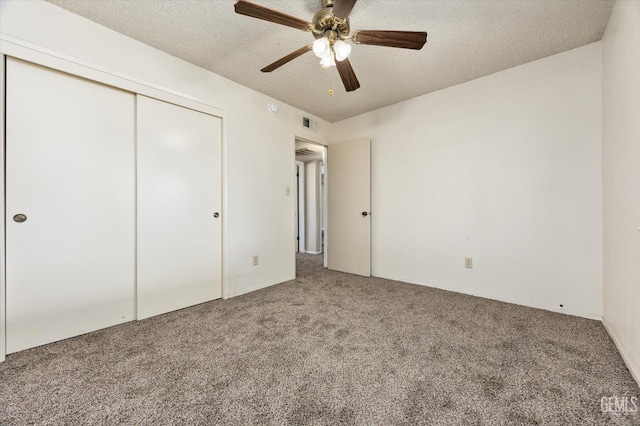 unfurnished bedroom with visible vents, a closet, carpet floors, and a textured ceiling