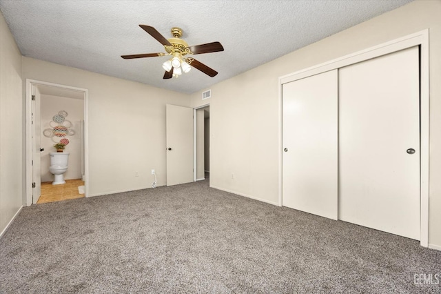 unfurnished bedroom featuring a closet, visible vents, carpet floors, and a textured ceiling