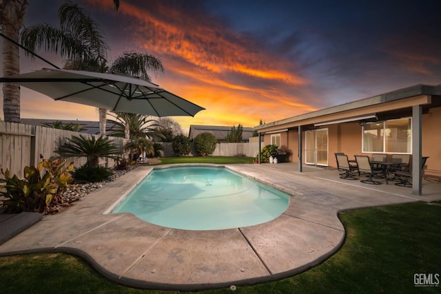 pool at dusk featuring a patio