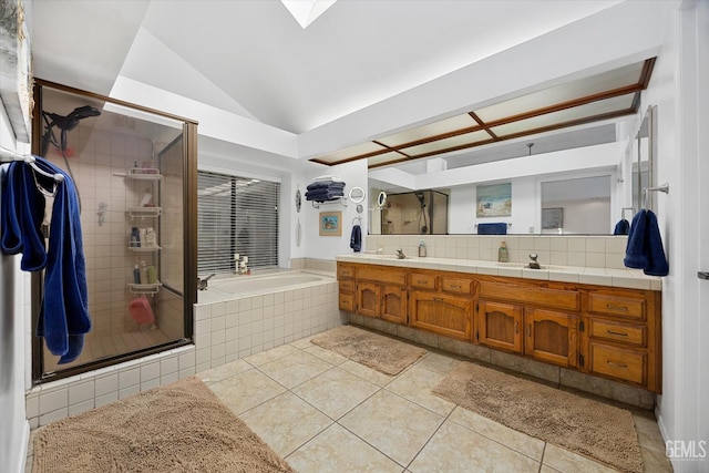 full bath featuring a garden tub, double vanity, a stall shower, vaulted ceiling, and tile patterned floors