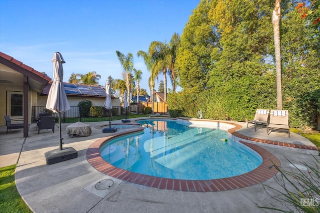 view of pool featuring a patio, fence, a fenced in pool, and an in ground hot tub