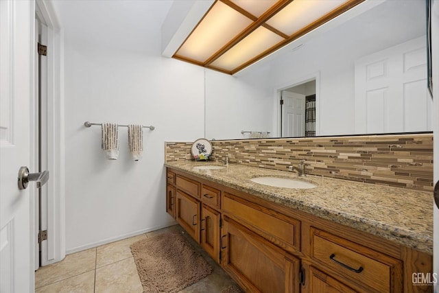 full bath with double vanity, backsplash, a sink, and tile patterned floors