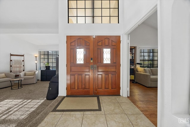 foyer entrance featuring a towering ceiling and light tile patterned floors