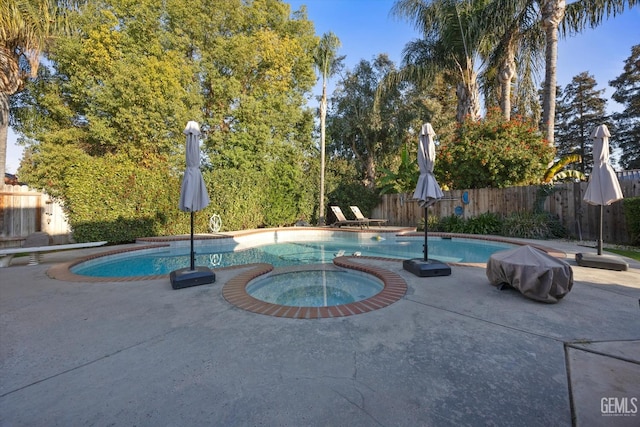 view of pool with a fenced in pool, fence private yard, a patio, and an in ground hot tub