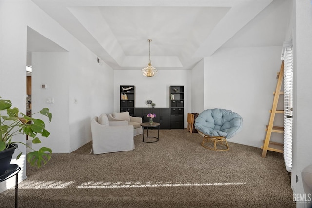 carpeted living room featuring a tray ceiling