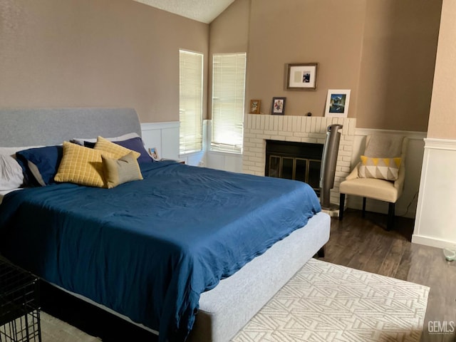 2304 Mountain Oak Rd, Bakersfield, CA 93311 - bedroom with wood finished floors, lofted ceiling, a wainscoted wall, and a brick fireplace