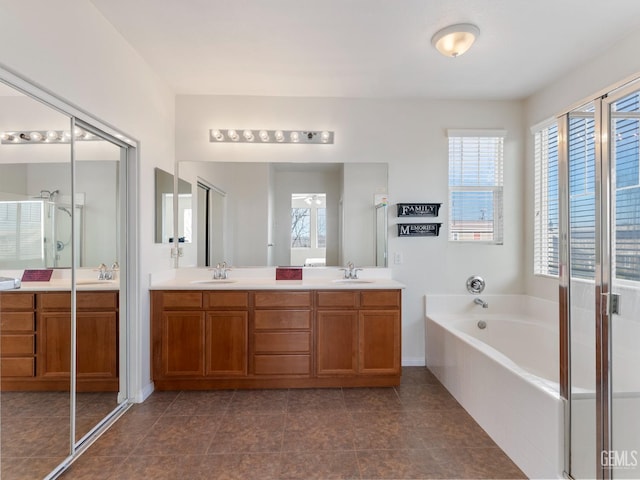 full bath with double vanity, a garden tub, and a sink