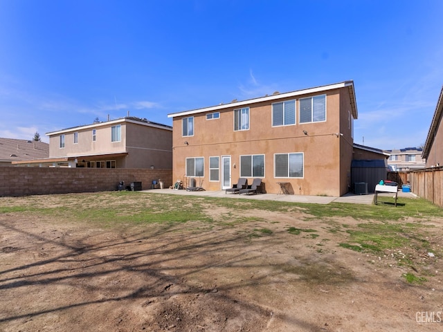 back of house featuring a patio area, a fenced backyard, and stucco siding