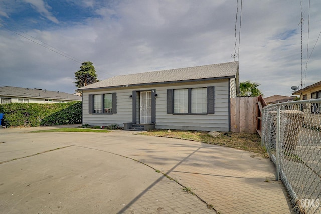 view of front of house featuring fence and roof with shingles