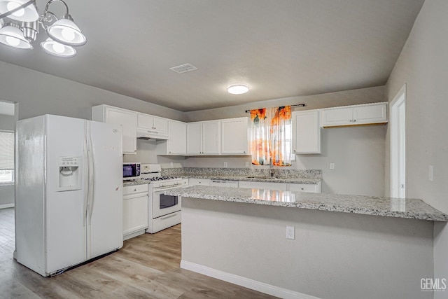 kitchen with light stone counters, a sink, white appliances, white cabinets, and visible vents
