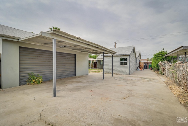 view of patio / terrace featuring fence and a garage
