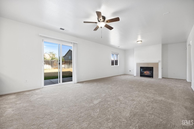 unfurnished living room featuring ceiling fan, carpet, and a fireplace