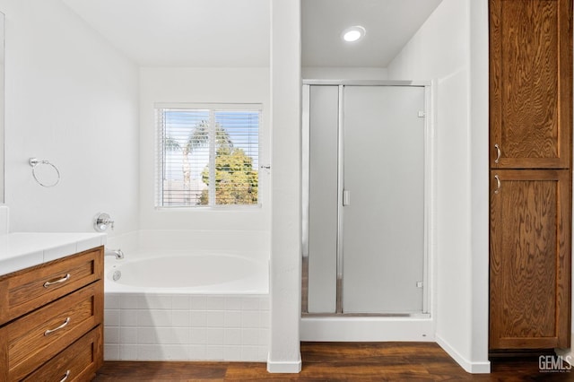 bathroom with hardwood / wood-style flooring, vanity, and separate shower and tub