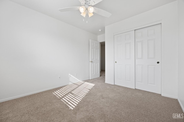 unfurnished bedroom featuring ceiling fan, light colored carpet, and a closet