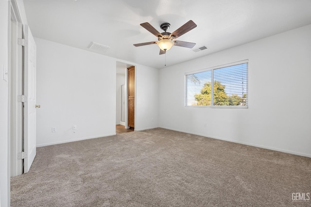 spare room featuring light colored carpet and ceiling fan