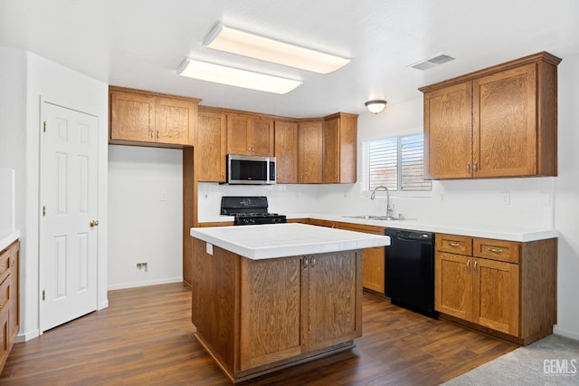 kitchen featuring sink, dark hardwood / wood-style floors, black appliances, and a center island