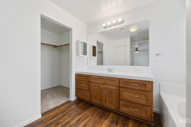 bathroom with vanity, a bathtub, hardwood / wood-style flooring, and ceiling fan