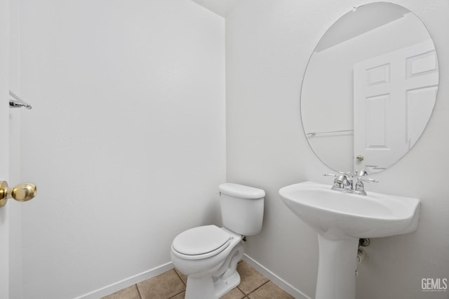 bathroom featuring sink, toilet, and tile patterned flooring