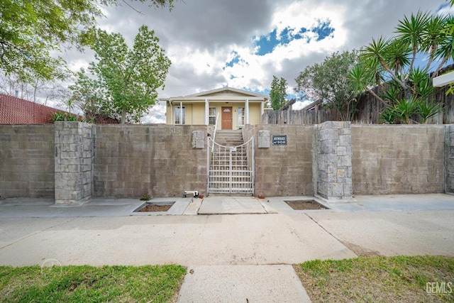 view of front facade featuring a fenced front yard and a gate