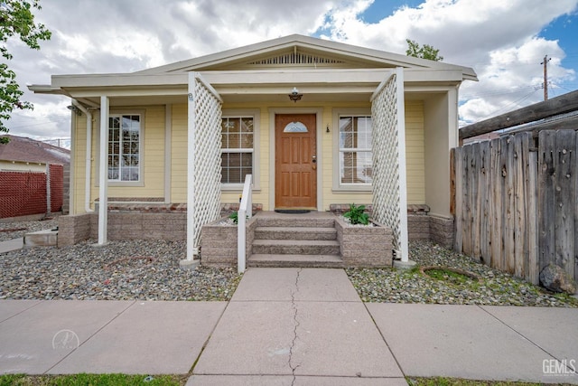 bungalow featuring fence