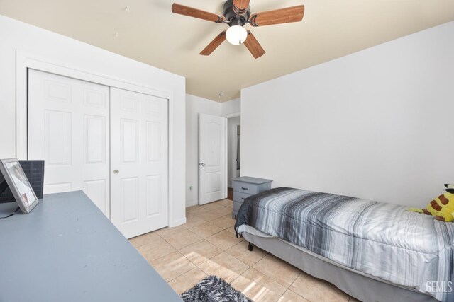 tiled bedroom featuring ceiling fan and a closet