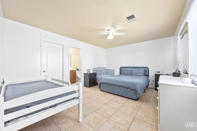 bedroom featuring light tile patterned floors, ceiling fan, and ensuite bathroom