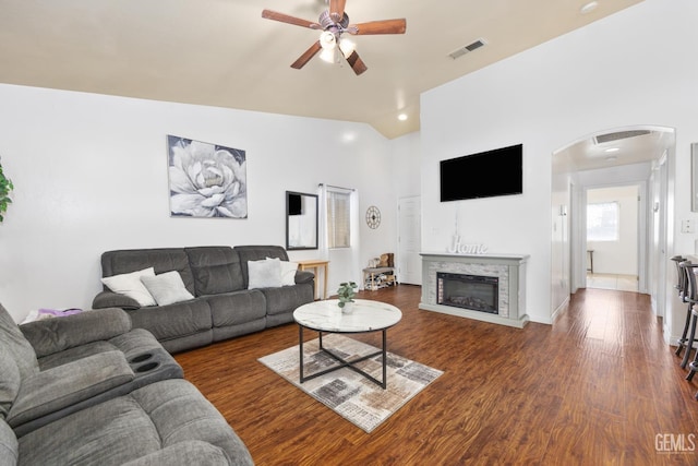 living room featuring vaulted ceiling, dark hardwood / wood-style floors, and ceiling fan