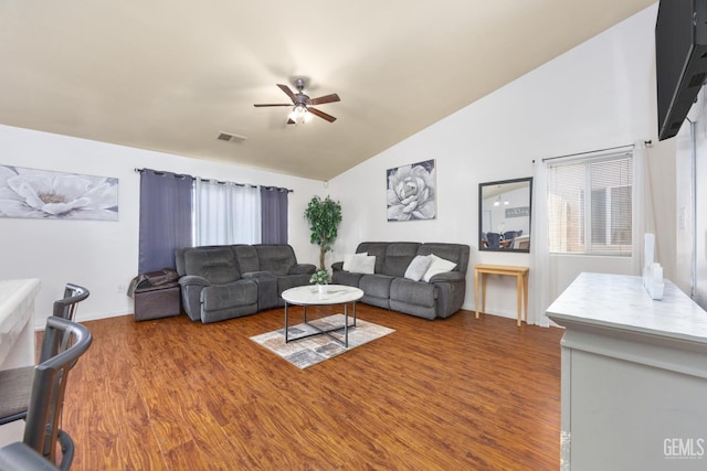 living room with ceiling fan, wood-type flooring, and vaulted ceiling