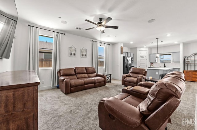 6607 Wind Wolfs Ln, Bakersfield, CA 93313 - living area featuring light colored carpet, a ceiling fan, plenty of natural light, and recessed lighting