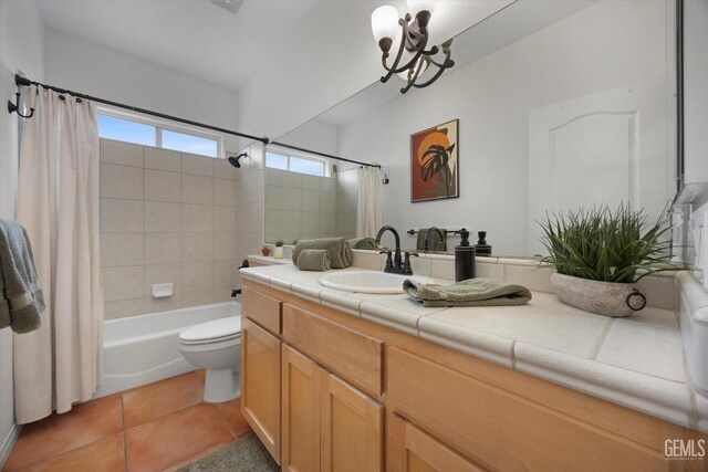 full bathroom with a notable chandelier, vanity, toilet, tile patterned floors, and shower / bath combo with shower curtain