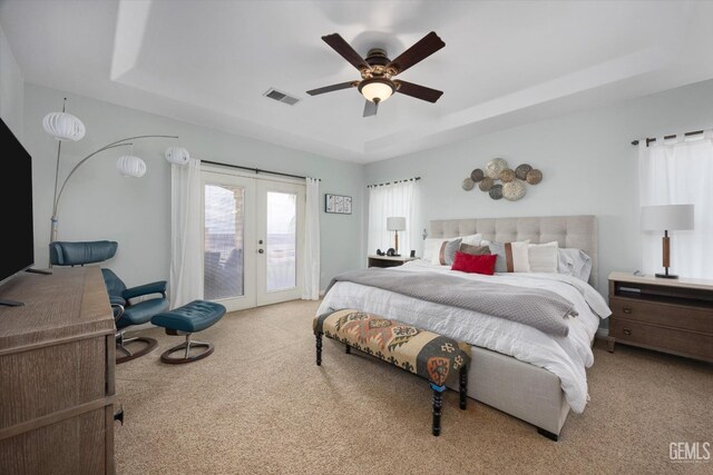 bedroom featuring french doors, visible vents, access to outside, carpet, and a tray ceiling