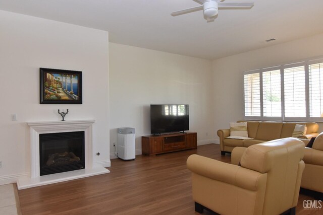 5712 Wisteria Valley Rd, Bakersfield, CA 93306 - living room featuring ceiling fan, wood finished floors, baseboards, and a glass covered fireplace