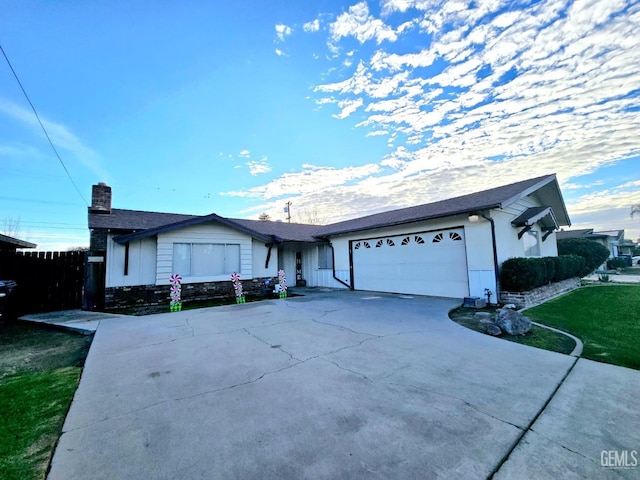 ranch-style home featuring a garage and a front lawn