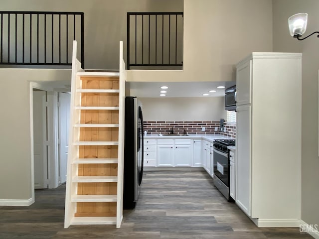 4700 Caliente Bodfish Rd, Caliente, CA 93518 - kitchen with stainless steel appliances, dark wood-style flooring, backsplash, white cabinets, and baseboards