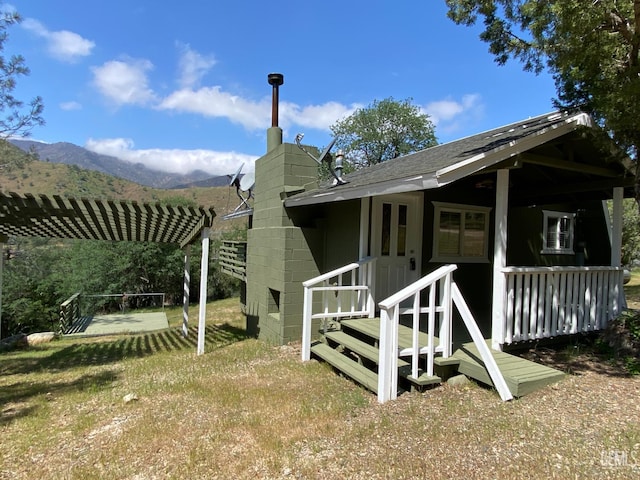 4700 Caliente Bodfish Rd, Caliente, CA 93518 - view of side of property featuring a pergola, a mountain view, concrete block siding, a chimney, and a shingled roof