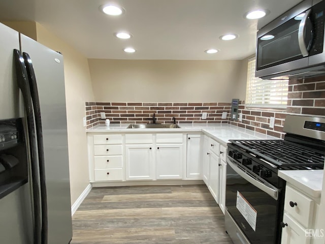 4700 Caliente Bodfish Rd, Caliente, CA 93518 - kitchen featuring stainless steel appliances, a sink, backsplash, light wood finished floors, and white cabinets