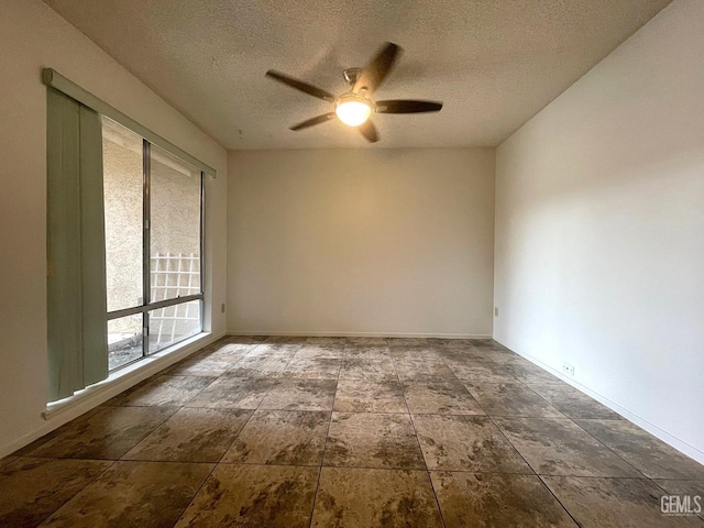 empty room featuring a textured ceiling, ceiling fan, and baseboards