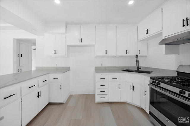 164 Rodriguez Ave, Shafter, CA 93263 - kitchen featuring stainless steel gas range oven, wall chimney exhaust hood, light wood finished floors, white cabinetry, and recessed lighting