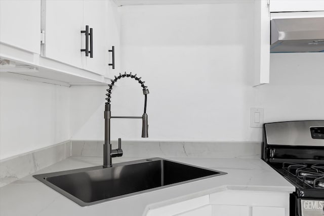 164 Rodriguez Ave, Shafter, CA 93263 - kitchen view of stainless steel gas range oven, wall chimney exhaust hood, white cabinetry, and light stone counters