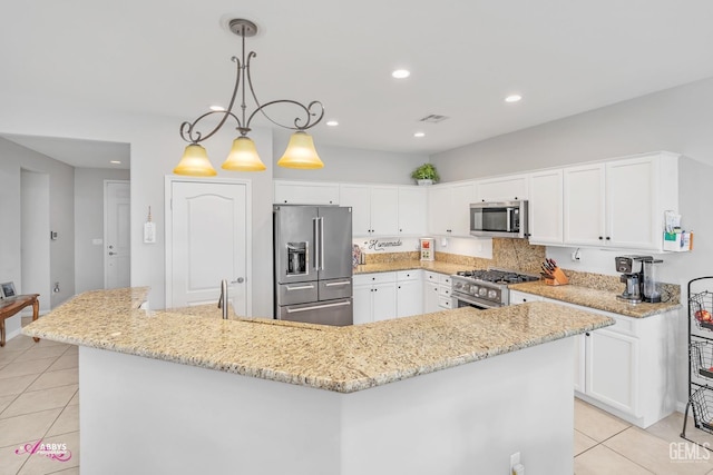 kitchen featuring light tile patterned floors, visible vents, high end appliances, and white cabinets