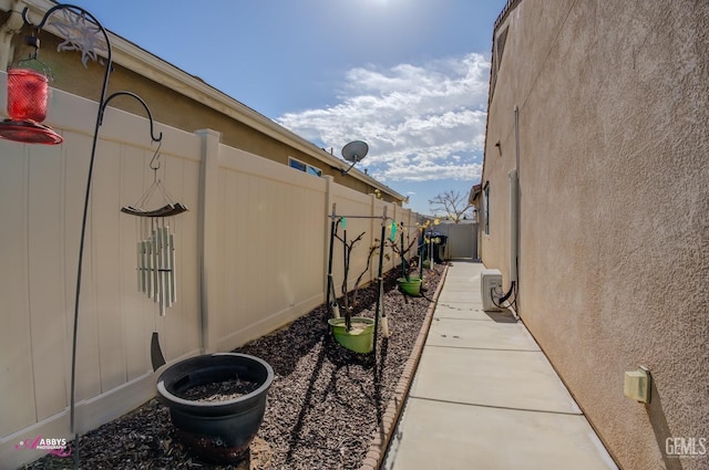 view of side of home featuring stucco siding and fence