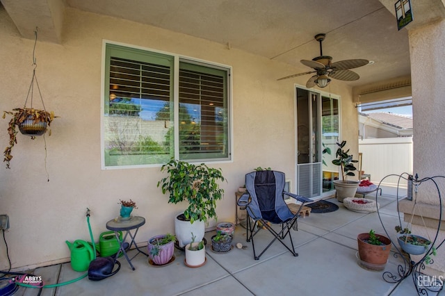 view of patio / terrace with ceiling fan and fence