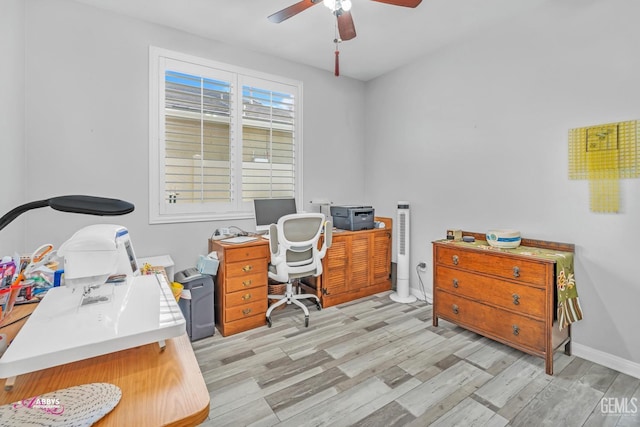 office space featuring baseboards, light wood-type flooring, and ceiling fan